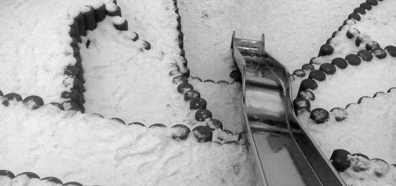 Grafische Linien mit silberner Rutsche im Schnee