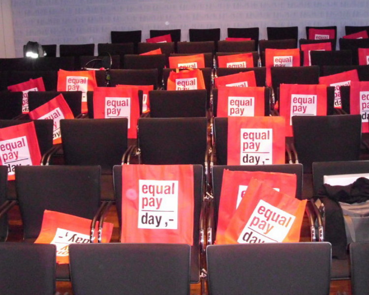 Equal Pay Day-Taschen liegen auf Stühlen