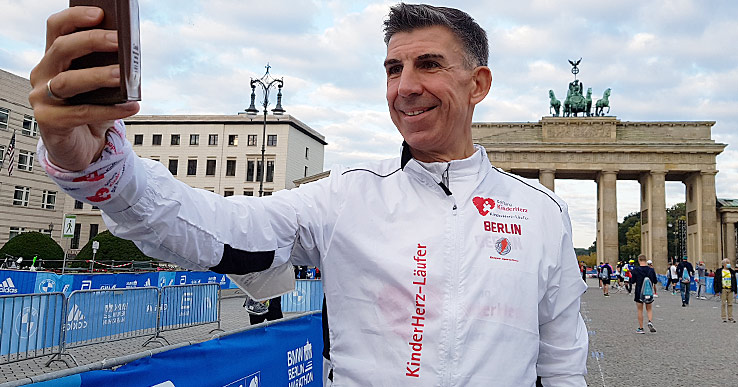 Alex Wieberneit macht am Brandenburger Tor ein Selfie vor dem Start zum 47. Berlin-Marathon