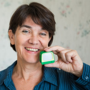 Die Journalistin Christine Olderdissen hält einen grünen Minifernseher vor ihr Gesicht